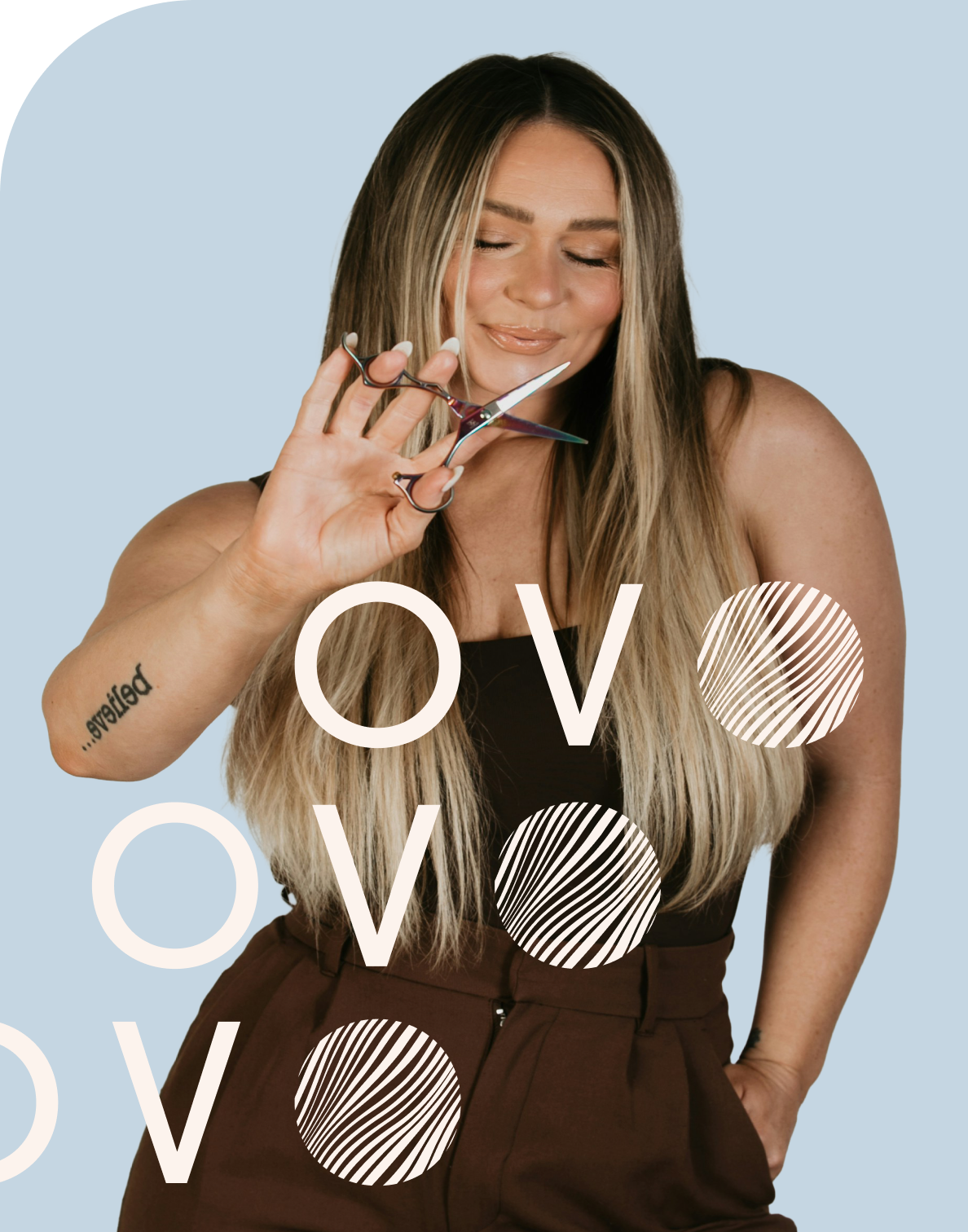 Stylist with staight blonde hair in brown dress posing with scissors with her eyes closed